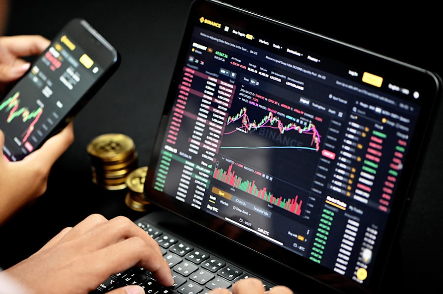 Crypto Trading graph is showing in a laptop screen and mobile screen where theme of image is black