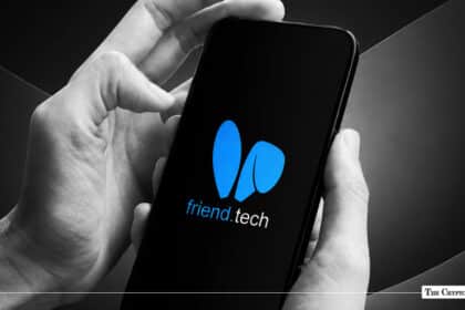 Hands holding a smartphone displaying the blue Friend.tech logo on a black screen
