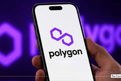 A hand holding a smartphone with the Polygon logo, representing the POL cryptocurrency market trends