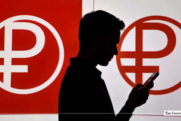 Silhouette of a person using a smartphone in front of large Digital Ruble symbol