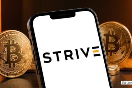 Smartphone screen displaying the Strive logo flanked by shiny physical Bitcoin coins on a dark surface