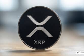 XRP coin with the XRP logo on a dark background.