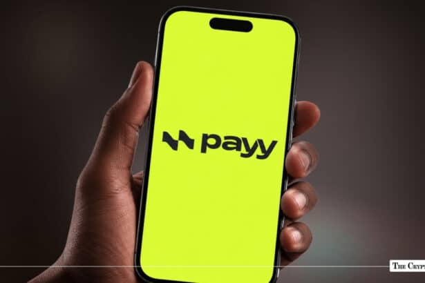 Smartphone displaying Payy app logo on a bright lime-green screen held in hand