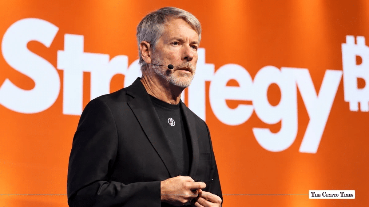 Michael Saylor speaking in front of a Strategy brand backdrop with an integrated Bitcoin logo.