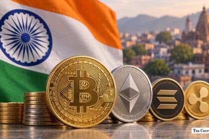 Bitcoin, Ethereum, Solana, and XRP coins arranged in front of an Indian flag with a city skyline in the background.