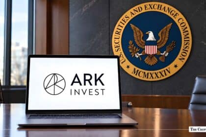 Laptop showing the ARK Invest logo placed on a desk in front of an SEC wall seal.