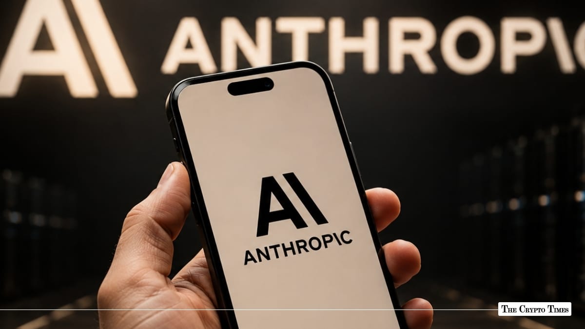Hand holding a smartphone displaying the Anthropic logo on screen in front of a wall with the Anthropic logo