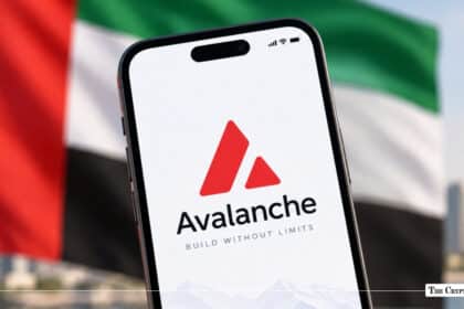 A smartphone displaying the Avalanche logo held in front of a blurred UAE flag