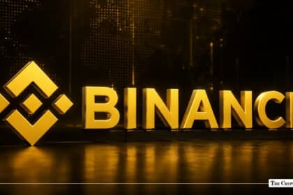 Gold 3D Binance logo and text illuminated on a dark background with reflections on the floor