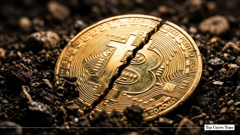 Cracked gold Bitcoin physical coin split in half on dark soil.