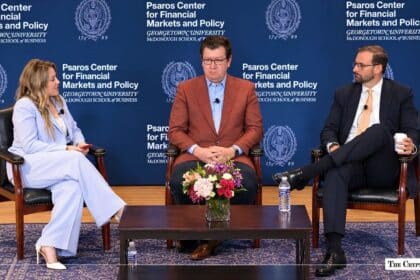 Three speakers seated on a panel stage at the Psaros Center for Financial Markets and Policy.