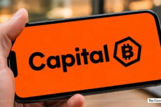 Smartphone displaying the Capital B logo with a Bitcoin emblem on a bright orange background