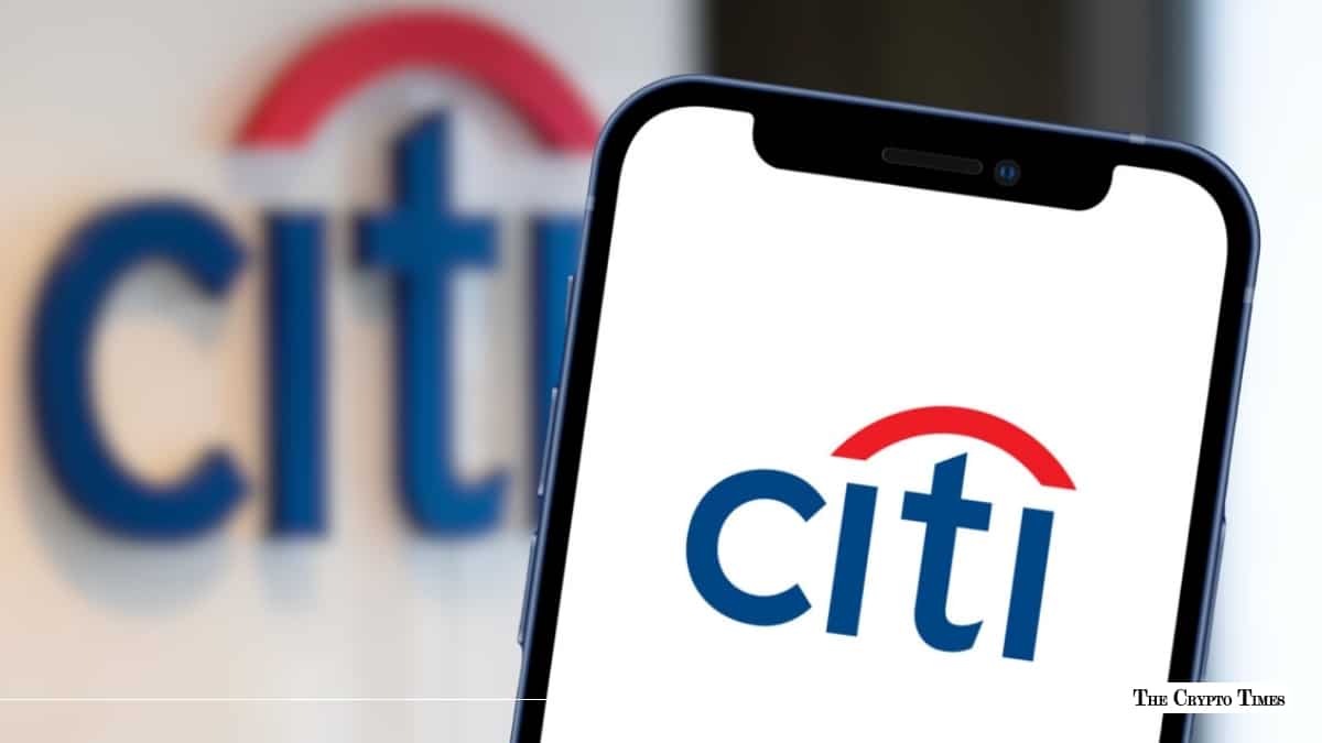 Smartphone displaying the Citi logo positioned in front of an out-of-focus Citi corporate sign
