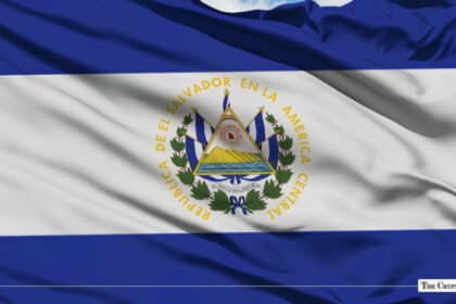 The national flag of El Salvador fluttering against a clear blue sky.