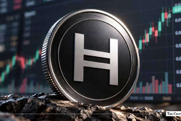A physical Hedera (HBAR) token coin resting on a rugged surface with a financial candlestick chart showing an upward trend in the background.