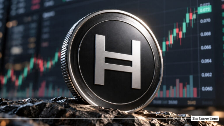 A physical Hedera (HBAR) token coin resting on a rugged surface with a financial candlestick chart showing an upward trend in the background.