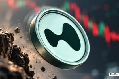 Silver crypto token coin featuring a dark abstract fluid logo crashing down near a declining red market chart