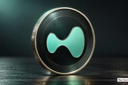 A metallic Hyperliquid (HYPE) coin with a green stylized symbol sitting on a dark surface.