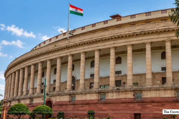 Indian Parliament building (Samvidhan Sadan) with the Indian national flag flying under a clear blue sky