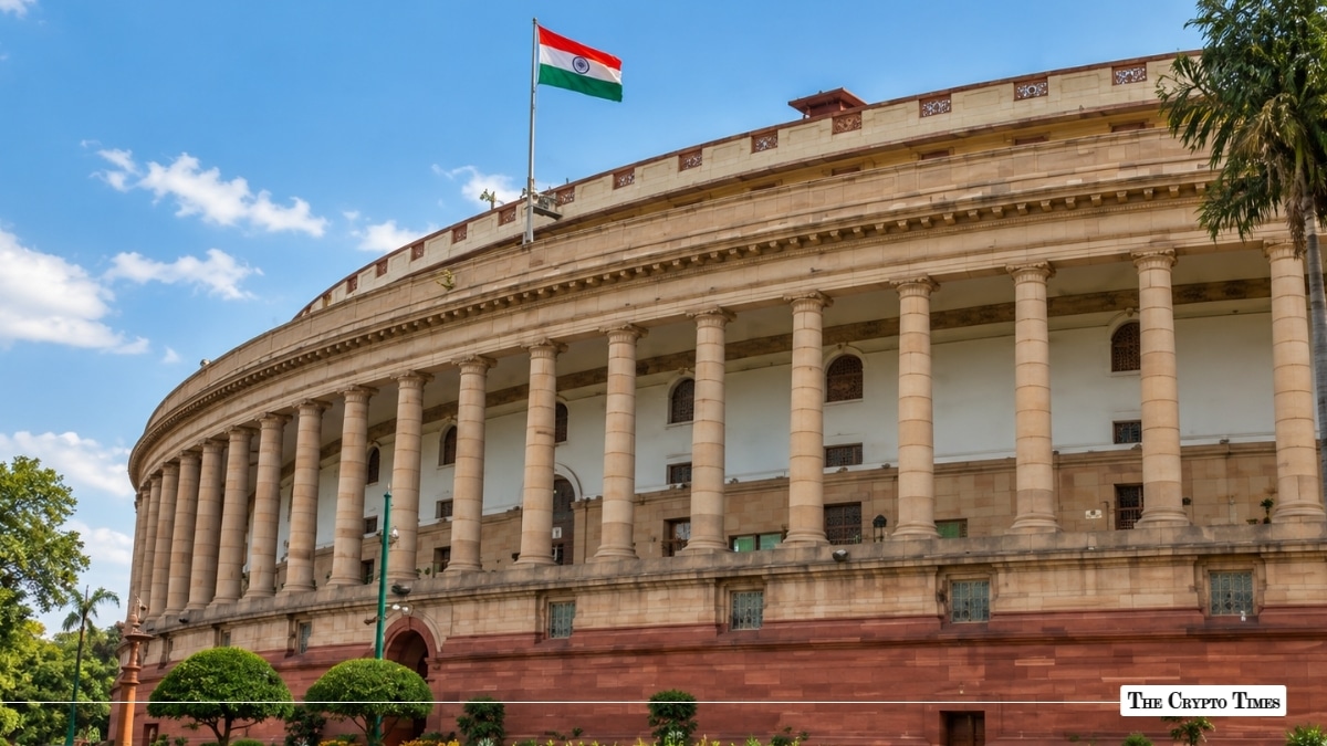 Indian Parliament building (Samvidhan Sadan) with the Indian national flag flying under a clear blue sky