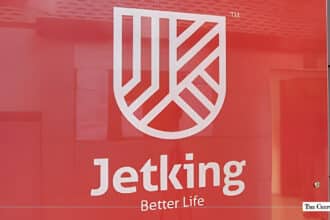 Jetking Infotrain corporate logo and shield emblem displayed on a red office wall background