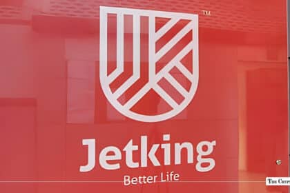 Jetking Infotrain corporate logo and shield emblem displayed on a red office wall background