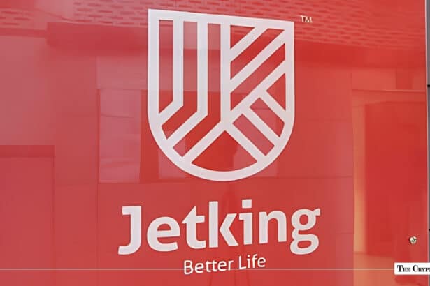Jetking Infotrain corporate logo and shield emblem displayed on a red office wall background