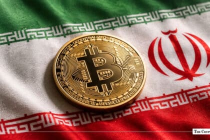 Gold Bitcoin coin resting on a fabric national flag of Iran