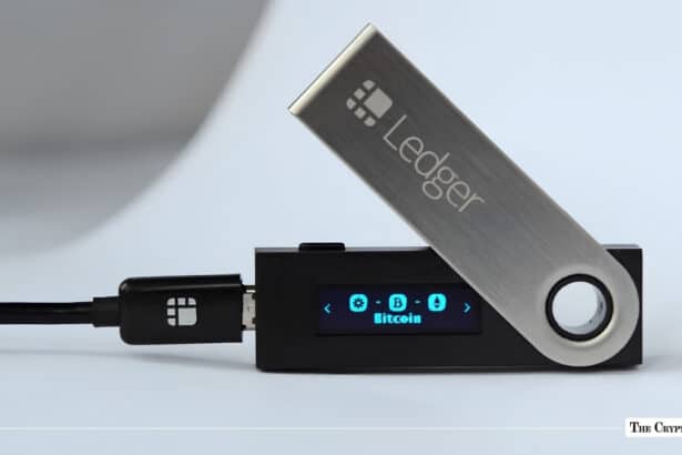 Black Ledger hardware wallet connected via USB displaying the Bitcoin icon on its digital screen