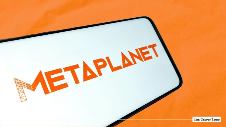Smartphone displaying the orange Metaplanet logo against an orange background.