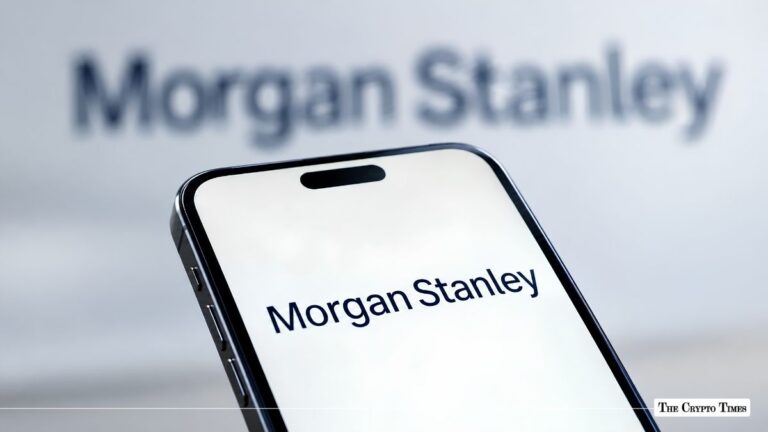 Smartphone screen displaying the Morgan Stanley logo held in front of a Morgan Stanley corporate wall sign.