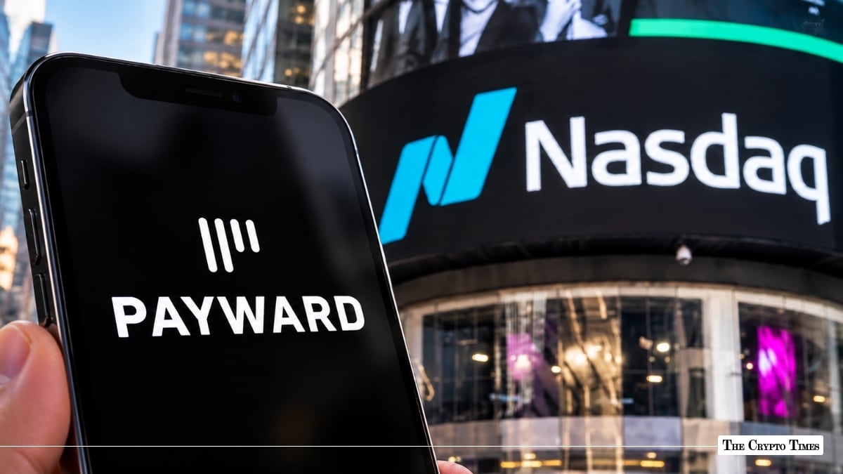 Hand holding a smartphone displaying the Payward logo set against the illuminated Nasdaq outdoor building sign in Times Square