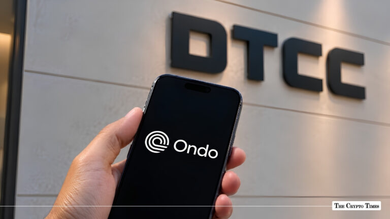 Hand holding smartphone displaying the Ondo Finance logo in front of DTCC wall signage.