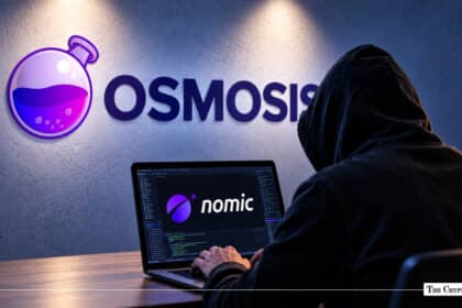 Hooded figure working on a laptop displaying the Nomic logo in front of a wall featuring the Osmosis logo