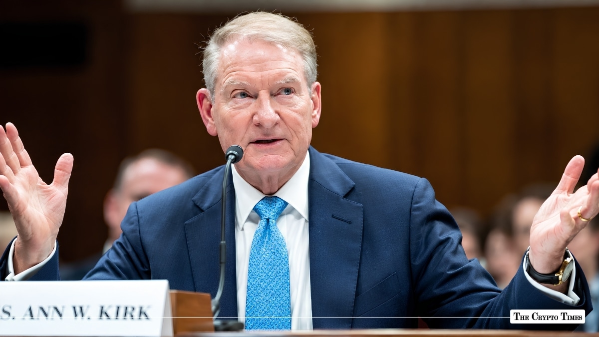 Official speaking into microphone with open hands at a hearing desk behind a nameplate reading "N W. KIRK".