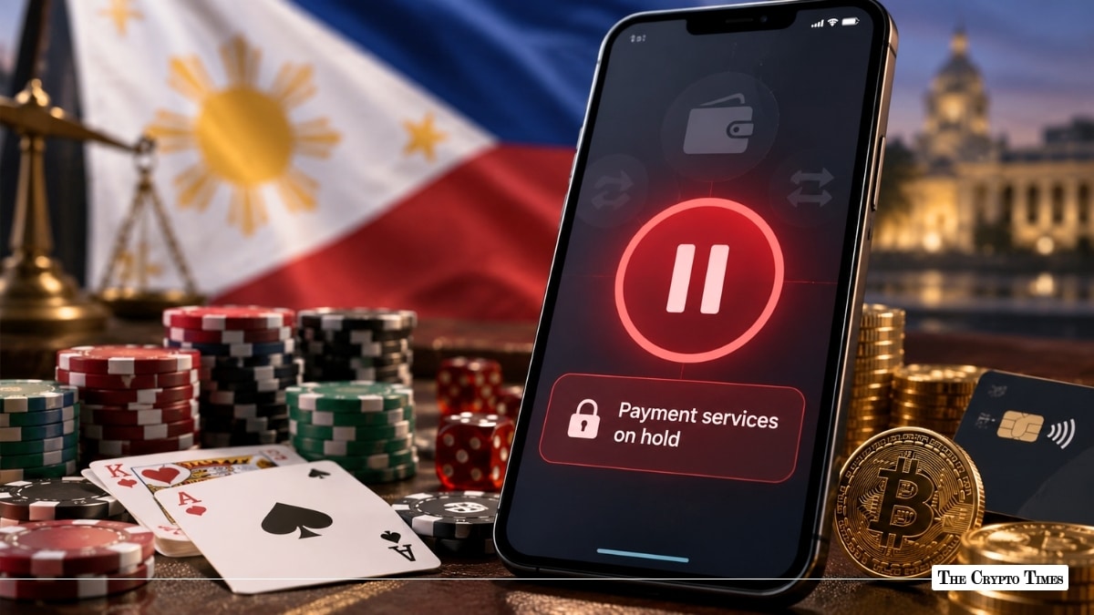 A smartphone showing a red "Payment services on hold" alert screen set against playing cards, poker chips, Bitcoin coins, and the flag of the Philippine