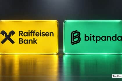 Side-by-side illuminated glass blocks displaying the yellow Raiffeisen Bank logo and green Bitpanda logo on a reflective surface.
