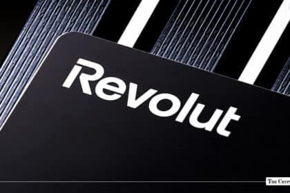 Black Revolut metal debit card with white embossed branding logo set against a textured geometric background