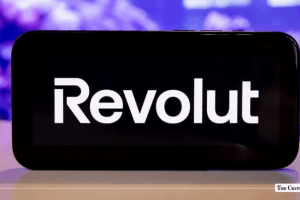 Smartphone displaying Revolut fintech and crypto app logo on screen against a blurred background