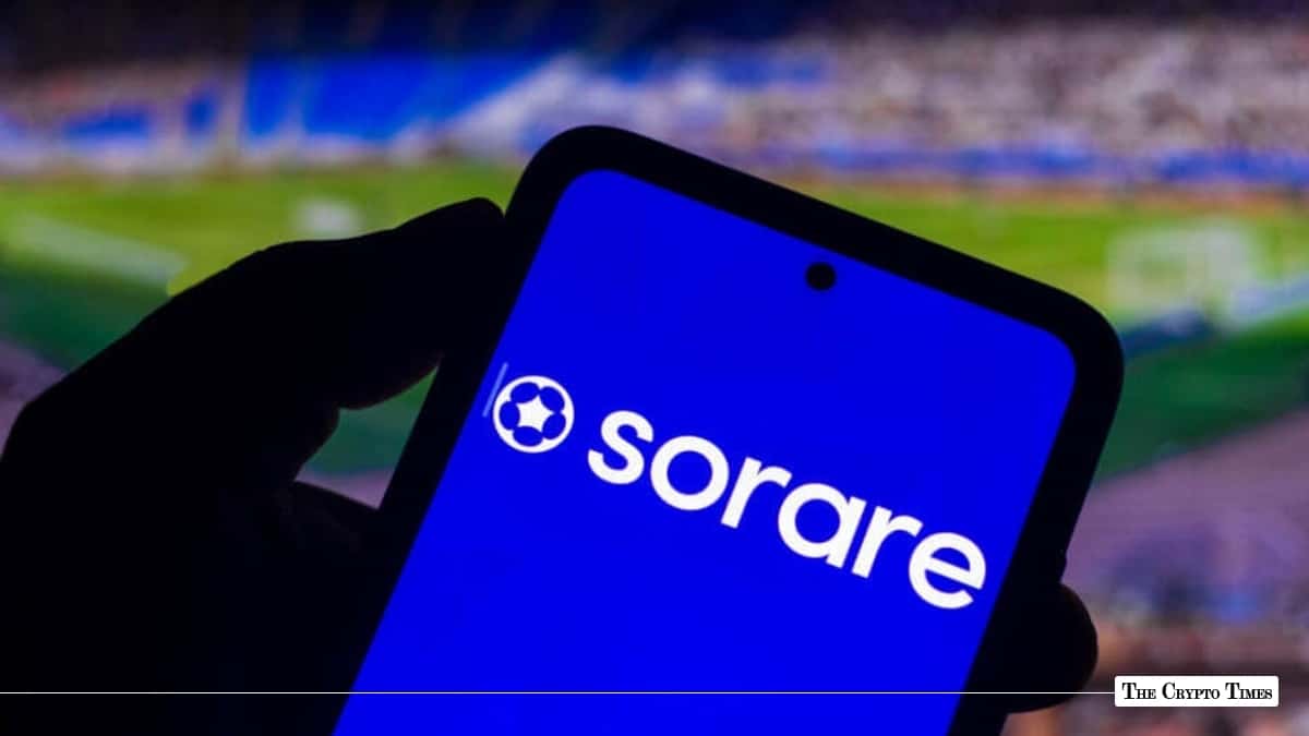 Smartphone displaying the Sorare logo on screen against a blurred football stadium background