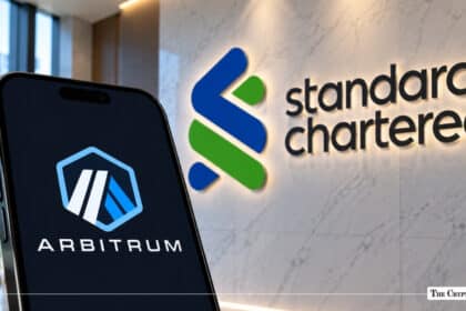 A smartphone showing the Arbitrum logo next to an illuminated Standard Chartered wall sign