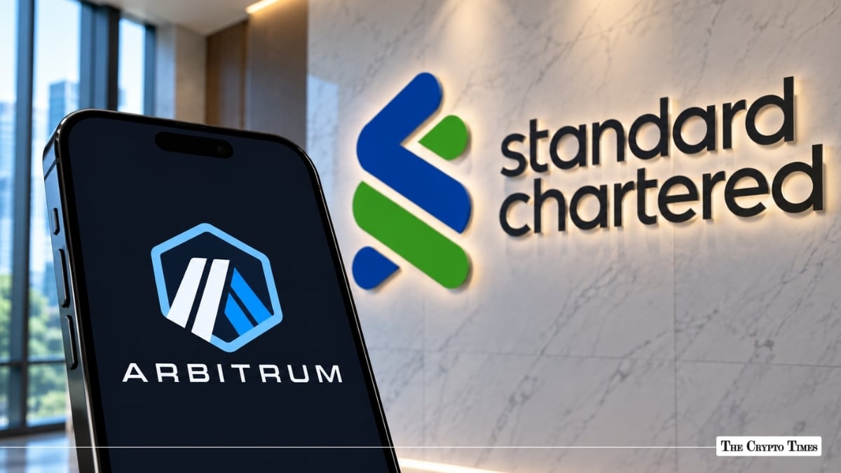 A smartphone showing the Arbitrum logo next to an illuminated Standard Chartered wall sign