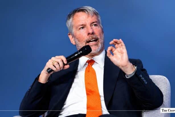 MicroStrategy Executive Chairman Michael Saylor holding a microphone while gesturing during a speaking engagement.