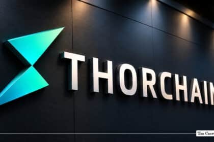 An illuminated 3D THORChain logo mounted on a dark wall under spotlights.