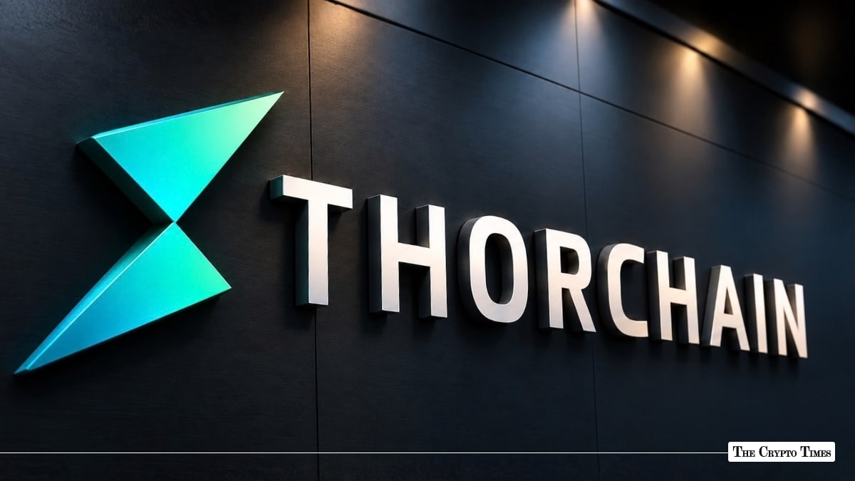 An illuminated 3D THORChain logo mounted on a dark wall under spotlights.