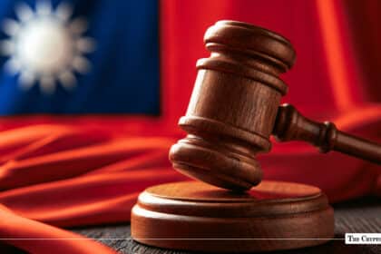 Wooden judge's gavel and sound block set against a blurred Taiwanese flag background