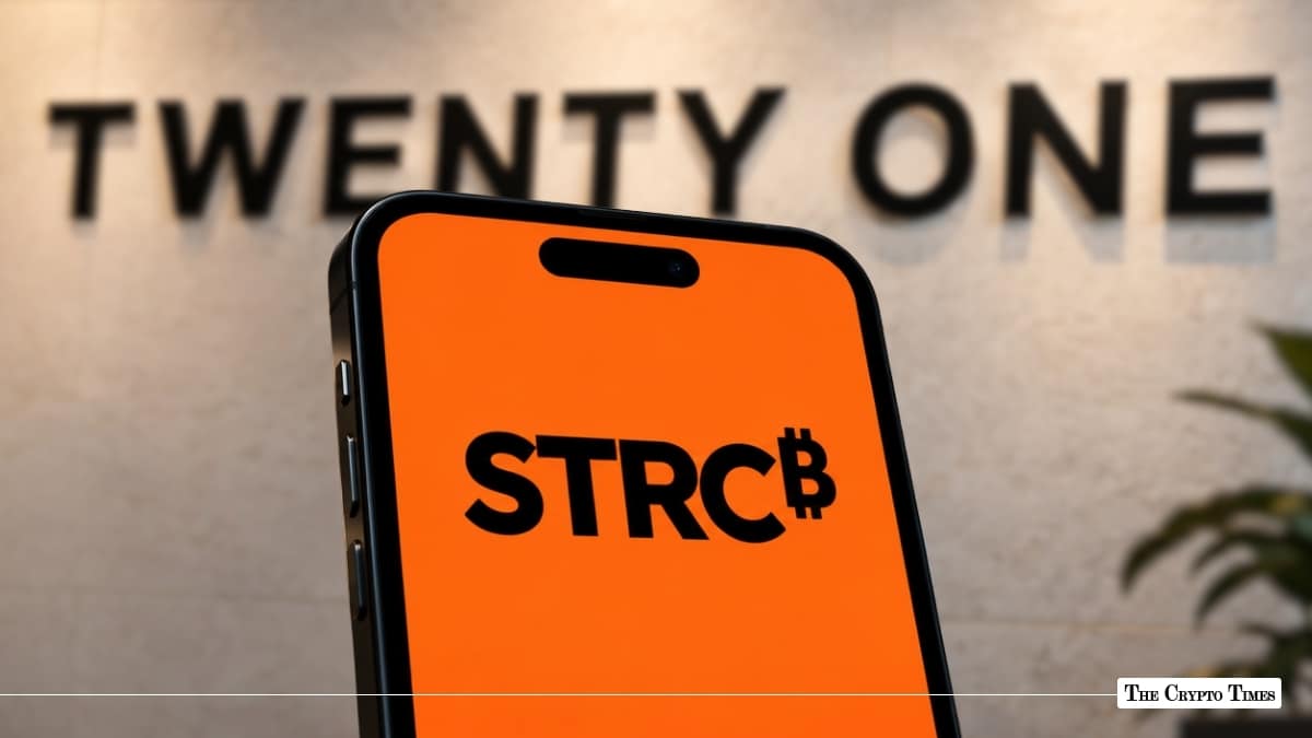 A smartphone displaying the STRC ticker with a Bitcoin symbol in front of a wall featuring the Twenty One Capital logo.
