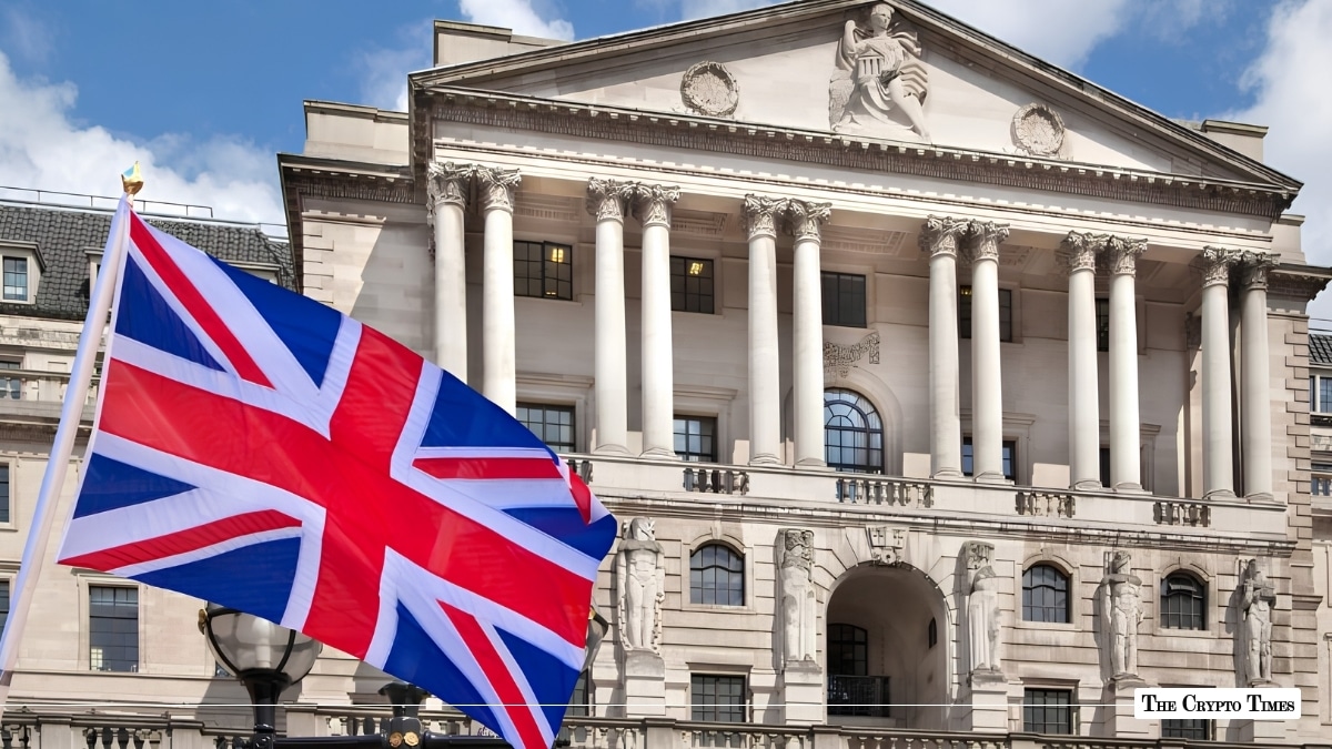 The UK flag flying in front of a classical stone financial building.