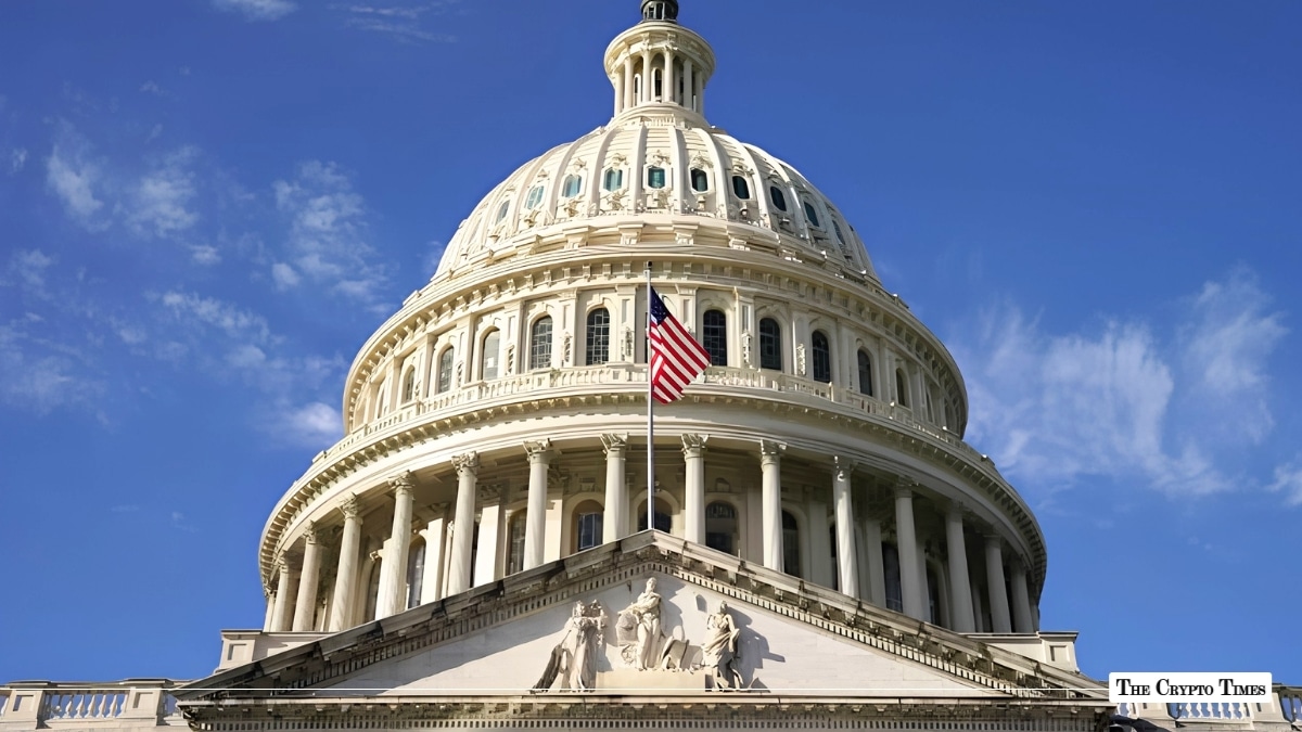 Low-angle exterior view of the United States Capitol dome under a clear blue sky with the American flag flying