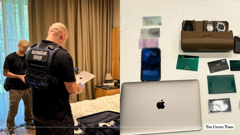 Ukrainian police officer inspecting a laptop during a room raid next to seized evidence including luxury watches, bank cards, and electronics.